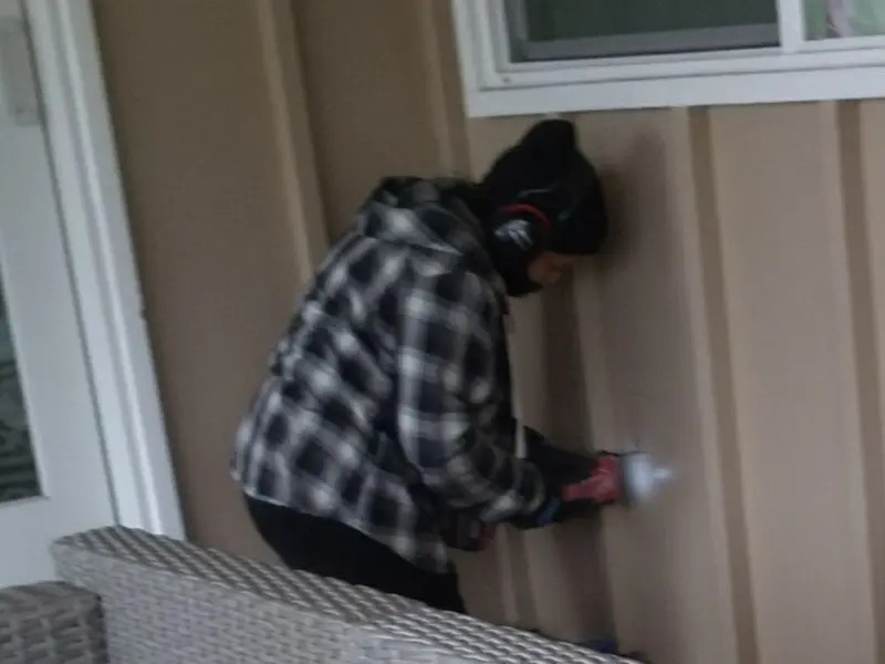 Professional electrician installing an exterior outlet in Raymond